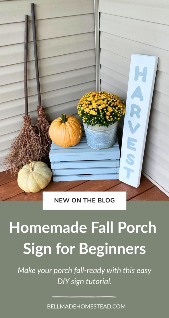 Fall porch sign with a crate, pumpkins, brooms, and mums on a porch