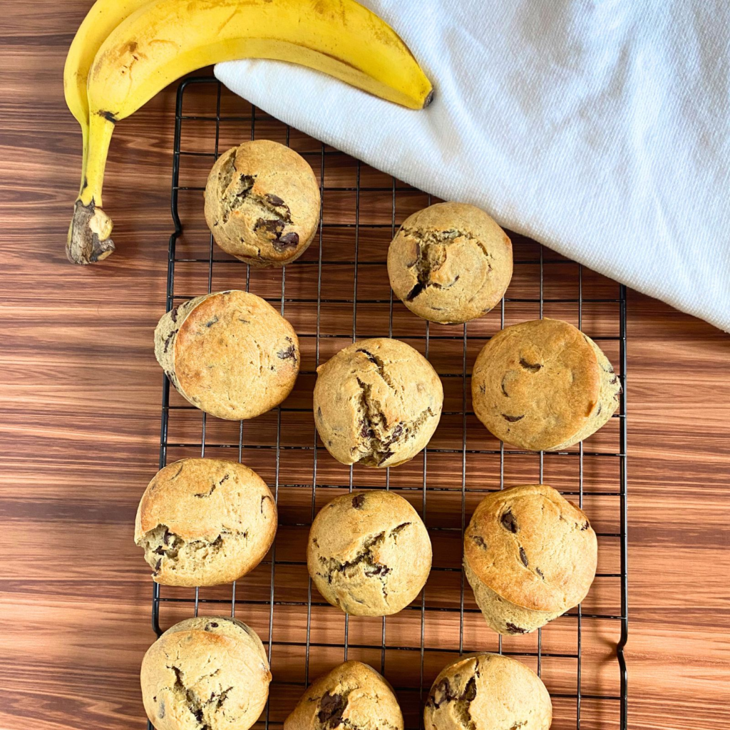 Muffins on a drying rack with bananas next to them