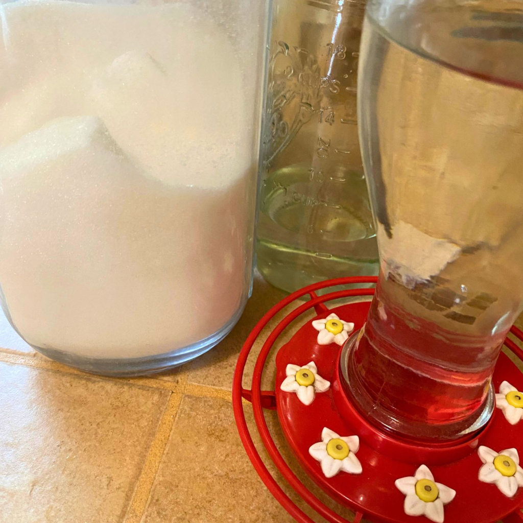 Red hummingbird feeder, glass jars with white sugar and water