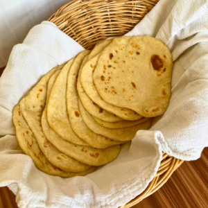 Sourdough tortillas in a basket with a white towel